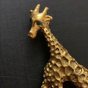 Giraffe brooch has green eyes